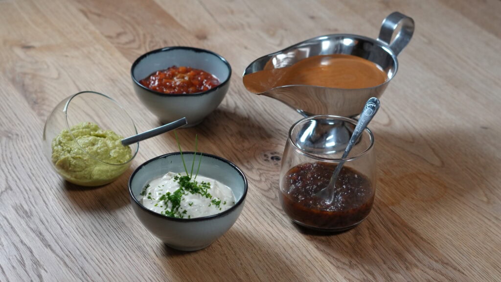 Fünf verschiedene Raclette Soßen und Dips in kleinen Schälchen, serviert mit Brot – Rezept von HausmannKocht.