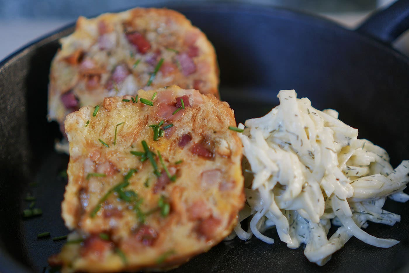 Angeschnittener Speckknödel mit grob gewürfeltem Südtiroler Speck und lockerer Brotstruktur